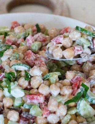 "High-protein chickpea salad with fresh vegetables, olive oil dressing, and herbs served in a healthy lunch bowl."