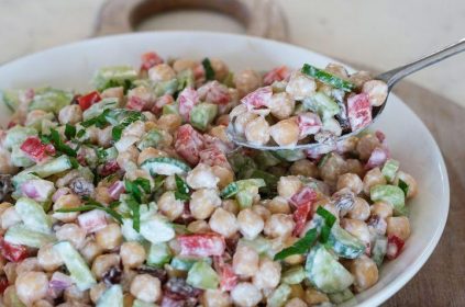 "High-protein chickpea salad with fresh vegetables, olive oil dressing, and herbs served in a healthy lunch bowl."