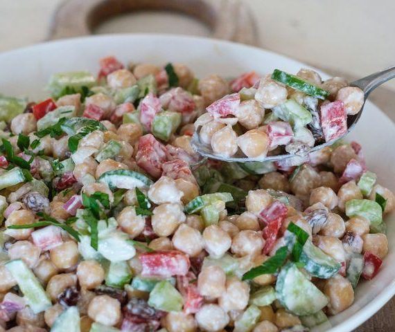 "High-protein chickpea salad with fresh vegetables, olive oil dressing, and herbs served in a healthy lunch bowl."