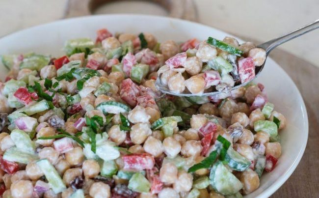 "High-protein chickpea salad with fresh vegetables, olive oil dressing, and herbs served in a healthy lunch bowl."