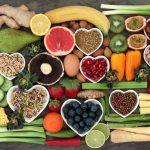 "Collection of healthy superfoods including blueberries, spinach, salmon, avocado, nuts, yogurt, and broccoli for a healthy lifestyle."